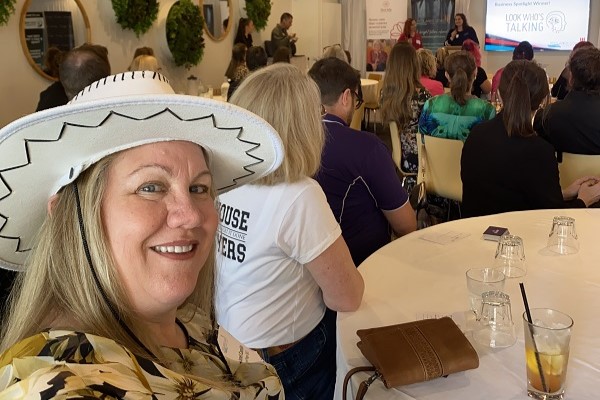 woman wearing a white cowboy hat at a business network event
